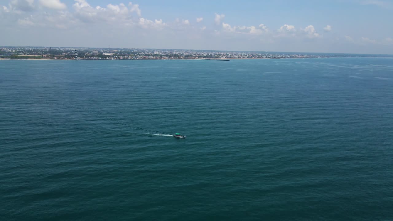 Picturesque aerial drone shot of a fishing boat set against the backdrop of the expansive ocean horizon.
