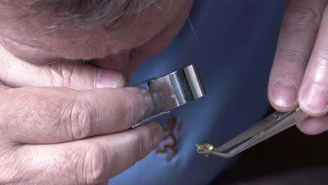 a jeweler inspecting a gemstone through a loupe, close up