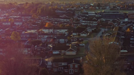 northwest uk townhouse estate aerial view with early morning sunrise light leaks over autumn coloured trees and rooftops