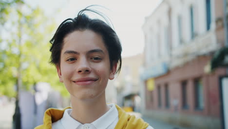 portrait of a smiling teenager on a city street
