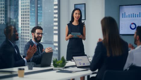 diversa reunión en la sala de conferencias de la oficina: la gerente superior asiática informa las estadísticas de crecimiento de las startups de comercio electrónico a un grupo de inversores. todo el mundo celebra grandes resultados. cámara lenta