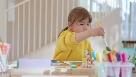 Calm-Girl-Enjoys-Studying-Drawing-Watercolors,-Little-Kid-Draws-With-Paints-and-Brushes-on-Paper