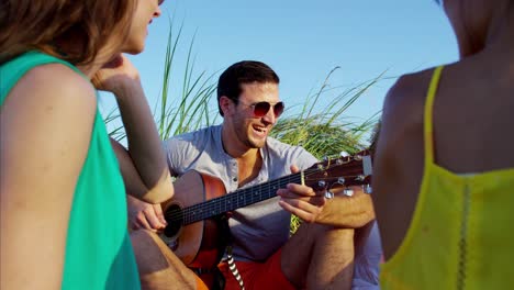 personas multiétnicas felices relajándose con picnic en la playa