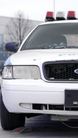 front view of a white police car with emergency lights