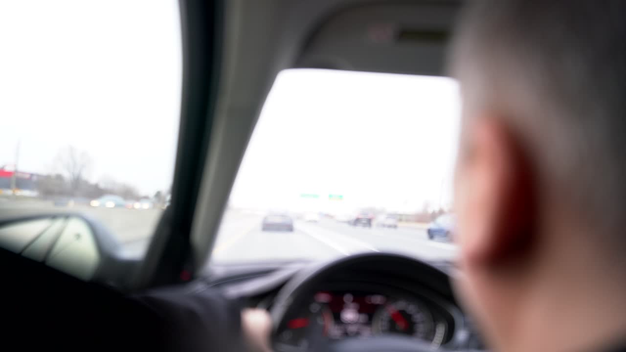 배경이 흐릿하고 전경이 흐릿한 차를 타고 고속도로를 달리는 백인 남성