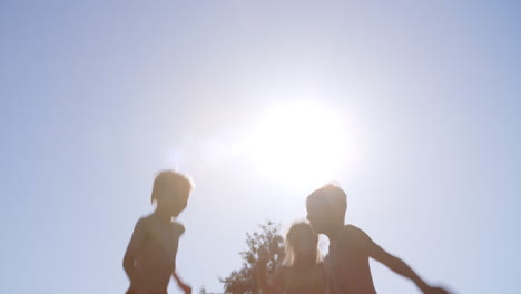 group of children having fun jumping on outdoor trampoline