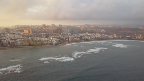 fantastic aerial shot forward showing the natural barrier of the beach and the wonderful beach of las canteras also the buildings in the area can be seen