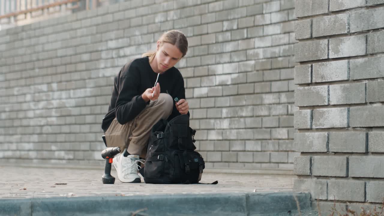 Mulher branca agachada junto a um muro de tijolos, inspecionando o conteúdo da mochila, com um meio-fio de concreto urbano, vestindo roupa casual com tênis, com um skate e garrafa de água ao lado, sob iluminação crepuscular melancólica, transmitindo uma vibração de documentário espontâneo.