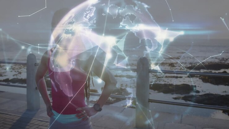 Animace digitálního glóbu nad osobou stojící u moře s rukama v bok.