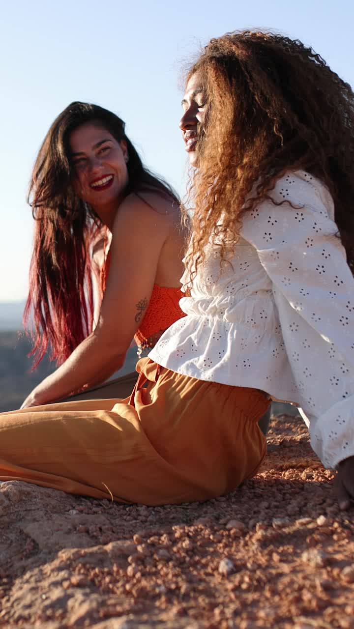 Dos mujeres jóvenes riendo y relajándose al aire libre