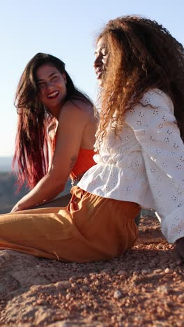 two young women laughing and relaxing outdoors
