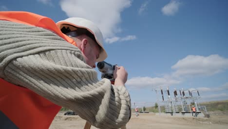 an engineer surveyor takes measurements at the construction of a transformer substation