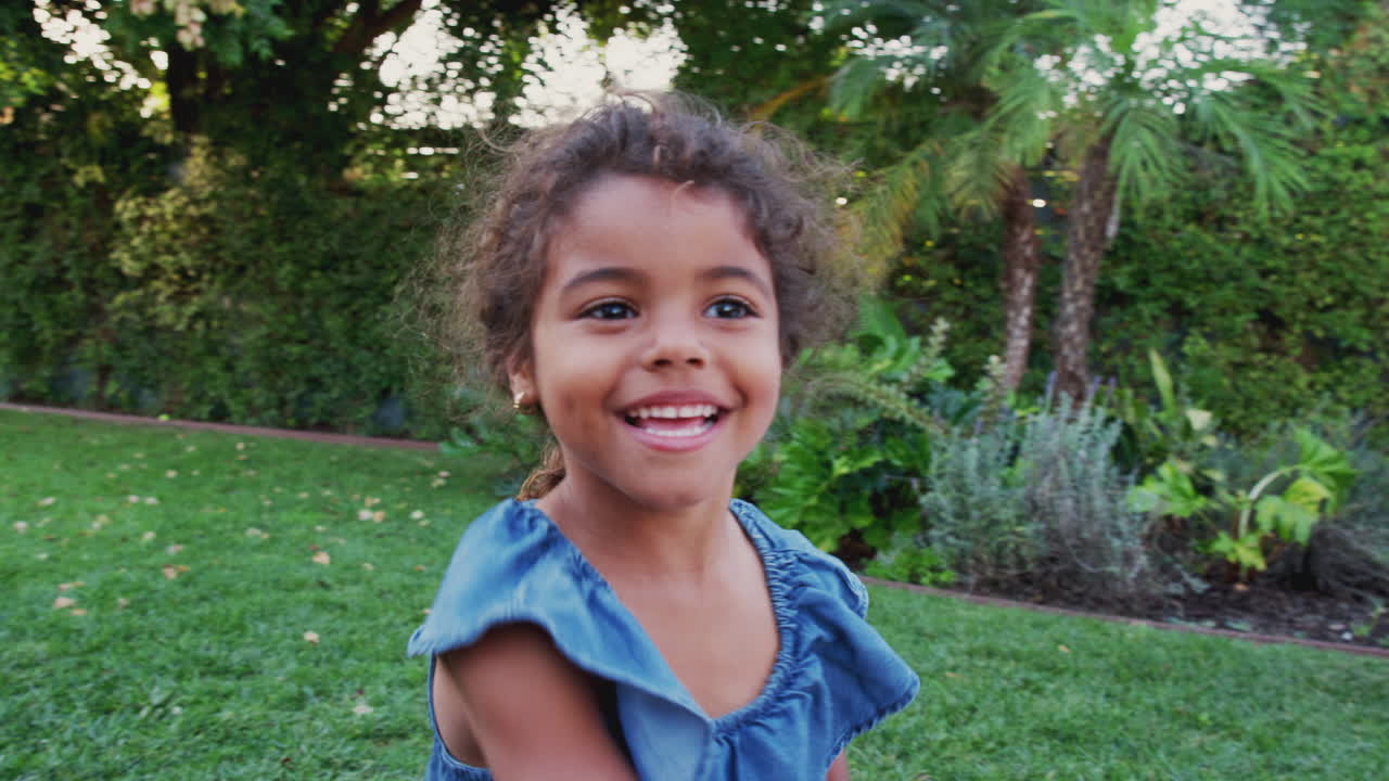 joven hispana persiguiendo y atrapando burbujas en el jardín