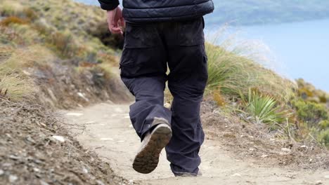 close up on the feet of a man hiking in ben lomond track, queenstown, new zealand