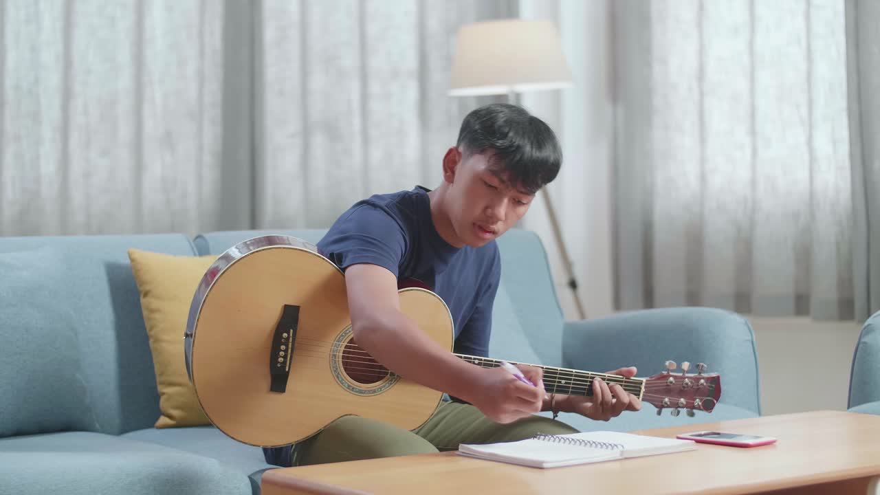 집에서 기타를 배우는 젊은 남자