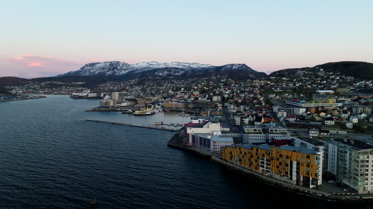 Aerial establishing of Harstad city along Norwegian coast, waterfront and harbor visible, orbit