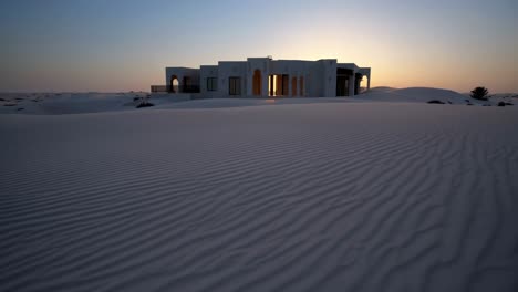 white house in the desert at sunset