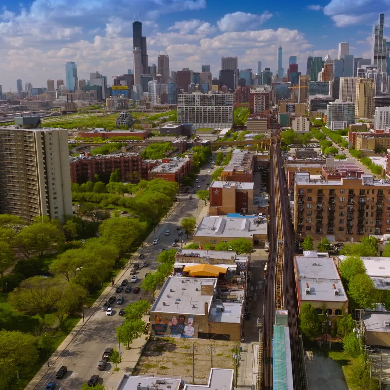 Sunny panorama of beautiful green districts of Chicago, Illinois. Gorgeous skyscrapers at the backdrop against blue cloudy sky