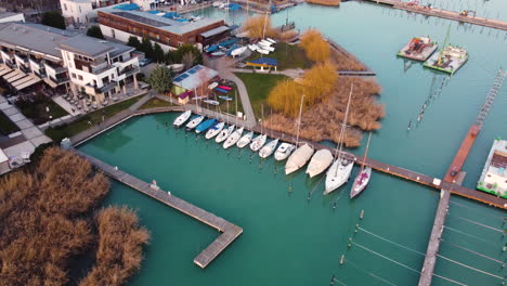 aerial clip of vibrant marina piers in balatonfured under golden light with boats in motion