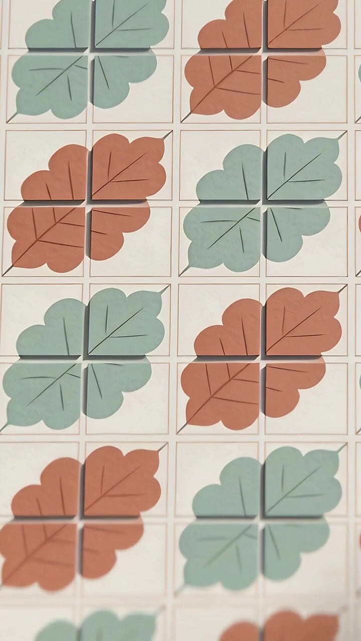 Vertical video: Panning camera showing slow shift at kitchen wall, square tiles with leaf motif