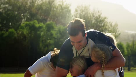 Happy-coach-hugging-a-children-in-park