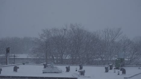 winter snow falling in slow motion on city building roof in slow motion 120fps