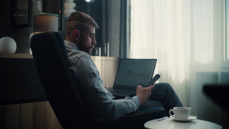 professional stock exchange broker talking on phone, analyzing real-time stocks and exchange market charts using laptop computer. successful investment agent works in cozy office of financial agency.