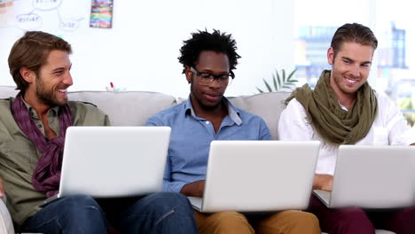 tres colegas usando una computadora portátil