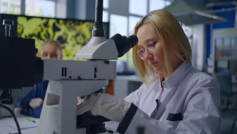 científico usando el microscopio en un laboratorio