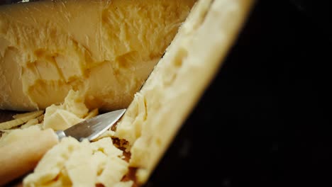 medium hard cheese head parmesan on wooden board, rotaiting shot
