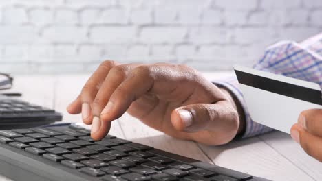 persoon die een online betaling maakt met een creditcard en een toetsenbord