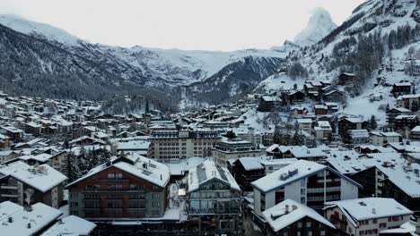 drone que se eleva lentamente sobre la ciudad de zermatt, suiza en un día de invierno
