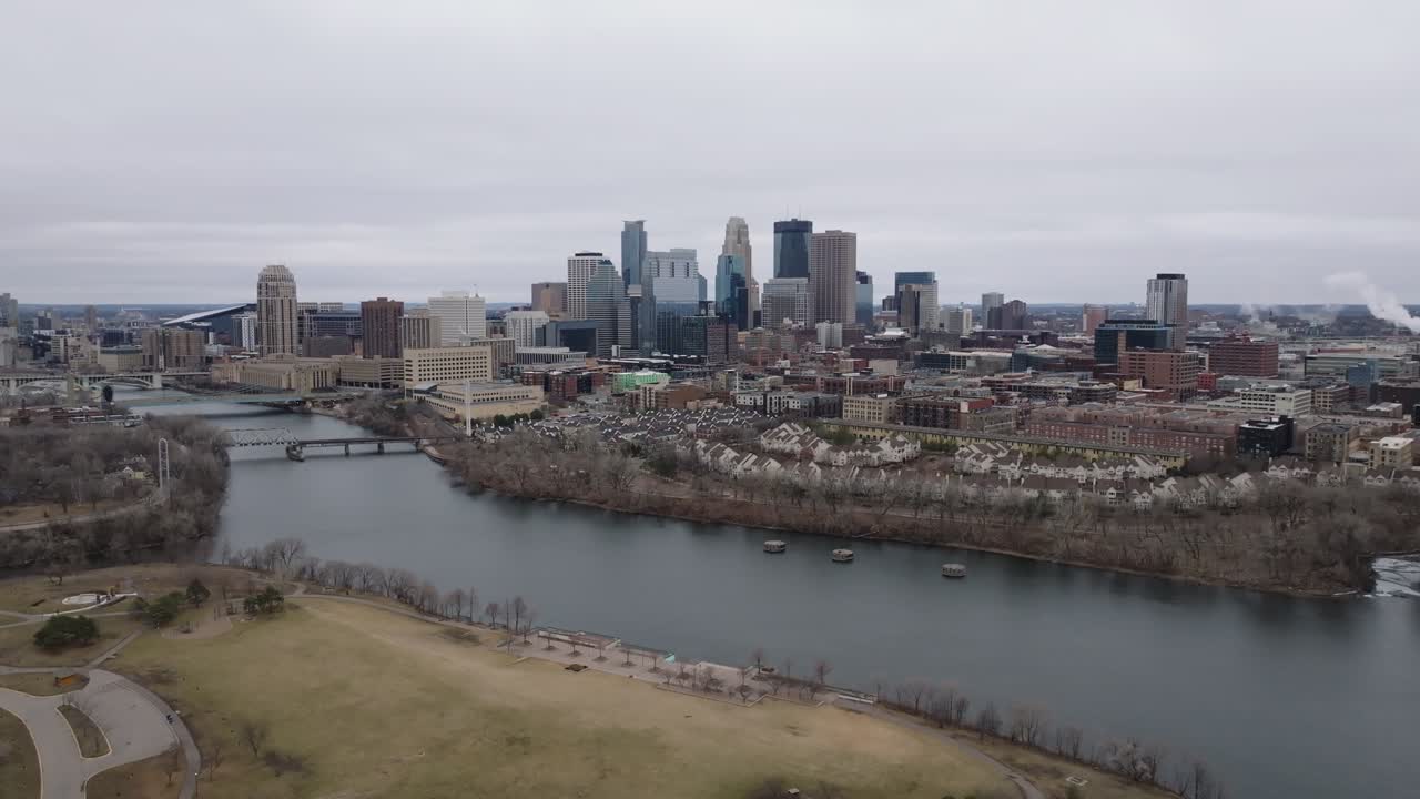 el horizonte de minneapolis con el río y los puentes bajo un cielo nublado durante el día, vista aérea