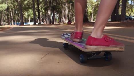 Riding-skateboard-along-the-park,-low-angle-tracking