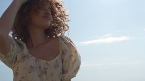 Cute-girl-frolicing-jumping-on-seashore-summer-day-close-up.-Woman-holding-hat.