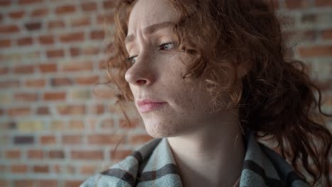 Front-view-of-caucasian-young-woman-covered-with-a-blanket-falling-down-on-sofa.