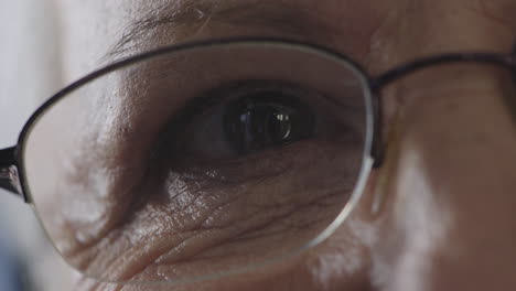 cerca del ojo de una mujer de mediana edad mirando a la cámara parpadeando con gafas