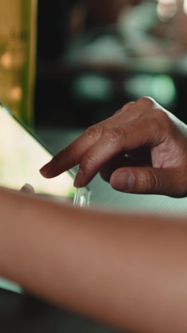 Primo piano di una persona che usa un tablet touchscreen in un caffè
