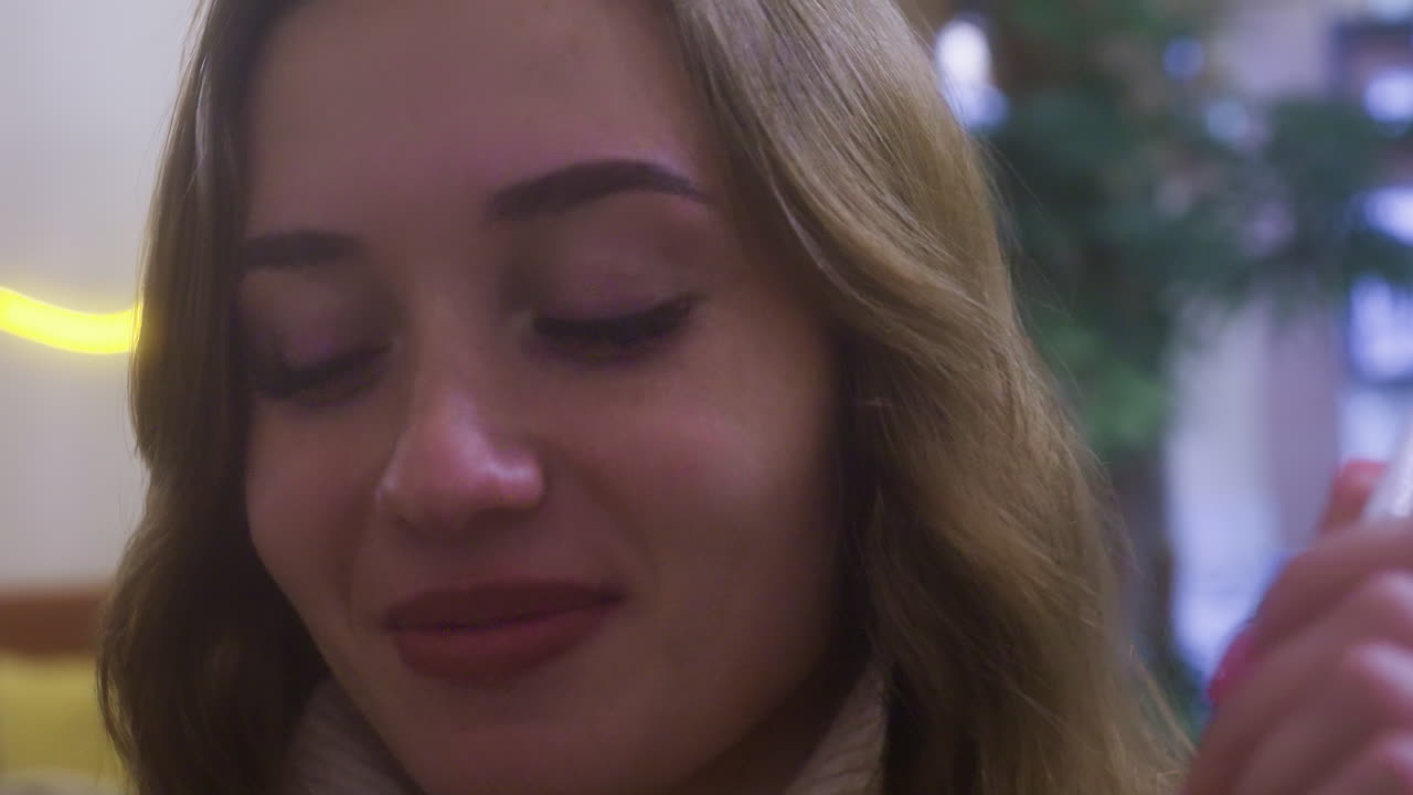 Close-up of lady in cafe smiling and licking fork, enjoying meal with playful expression. Soft lighting creates a relaxed ambiance, capturing lighthearted moment in cozy cafe setting