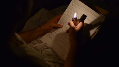 a soldier reading a letter at night with a zippo lighter