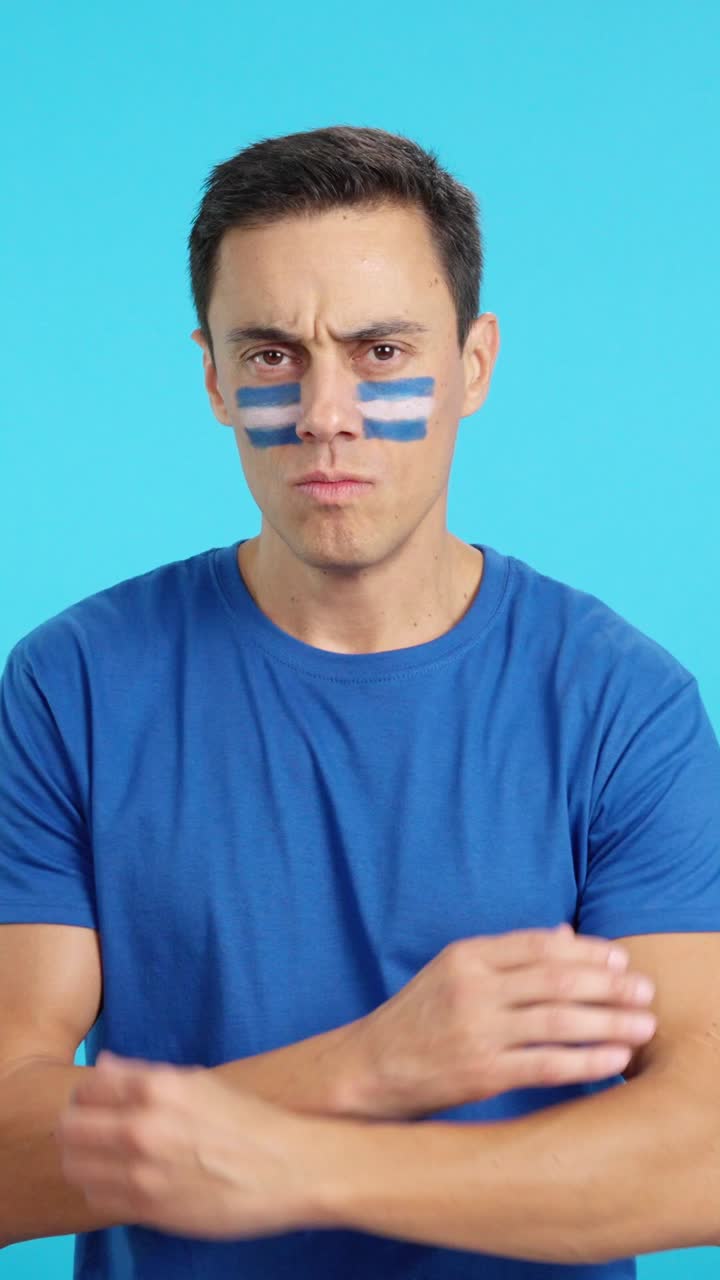 Dignified and serious man with salvadoran flag painted on face