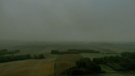 Aerial-footage-over-filed-during-foggy-morning,-Cloudy-sky-and-natural-landscape-around,-drone-4K,-warmia-and-masuria,-Poland