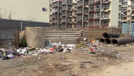 toxic industrial waste dumped next to a poor residential area in china. smoke coming from garbage bags. terrible environment pollution in chinese cities. dangerous and unhealthy living environment