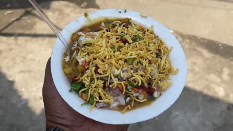 Alu-tiki-chat-with-sev-matar-onion-chilli-and-coriander-leaves-in-road-side-shop-in-Dhobi,-Gaya,-Bihar