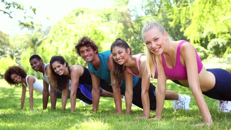 clase de fitness haciendo flexiones en el parque