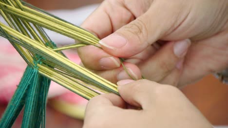 fingers separating yellow and dark green yarn in