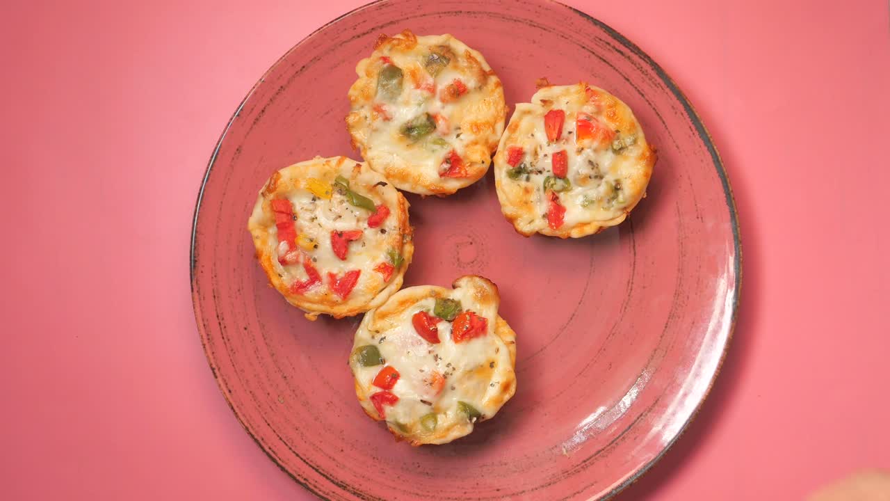 mini pizzas en un plato rosado