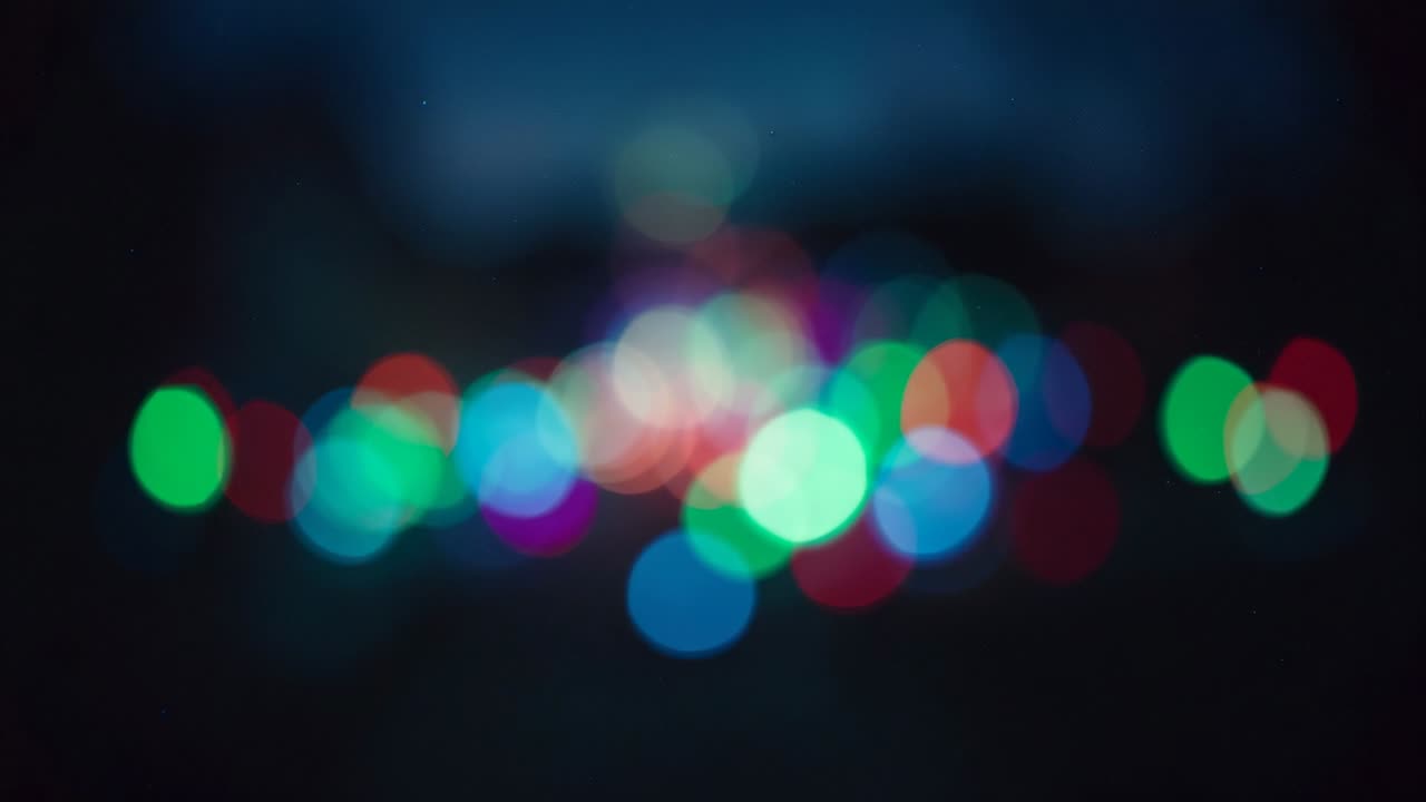 Starting camera recording defocused colorful light orbs on urban street at night, for bokeh effect