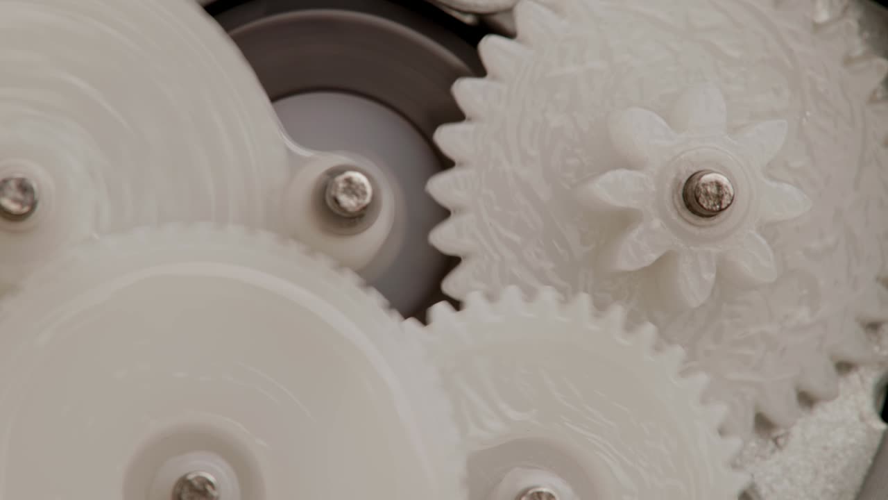 cinco engranajes de plástico giran en malla mutua dentro de un pequeño engranaje de reducción