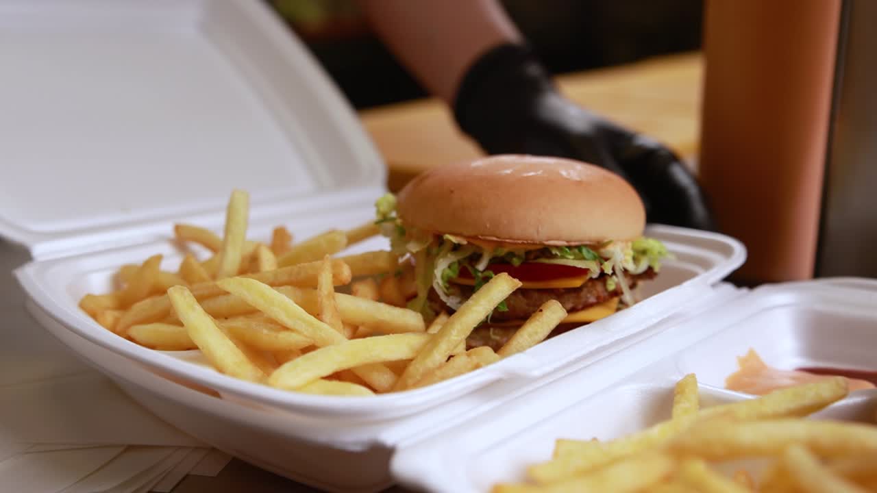 preparando pedidos para llevar con papas fritas y una hamburguesa